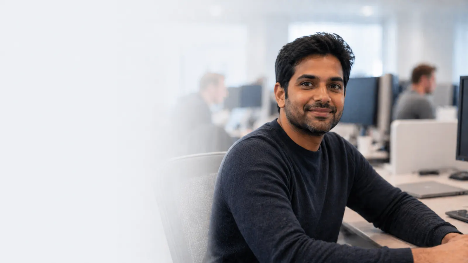 NRI software engineer returning to India NRI software engineer at his office desk, planning his return to India through talent.backtoindia